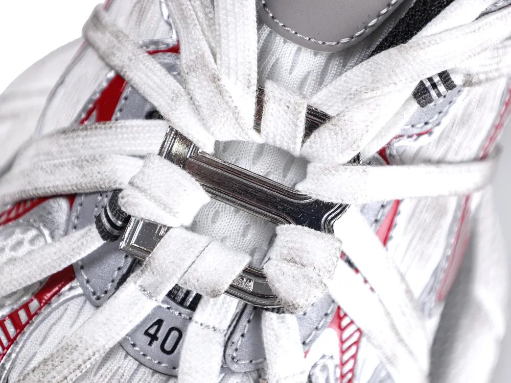 White and red fabric sneaker with white laces and silver metal eyelet detail.