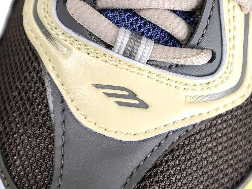 Close-up of a shoe's upper part with brown mesh, blue fabric, and beige leather.