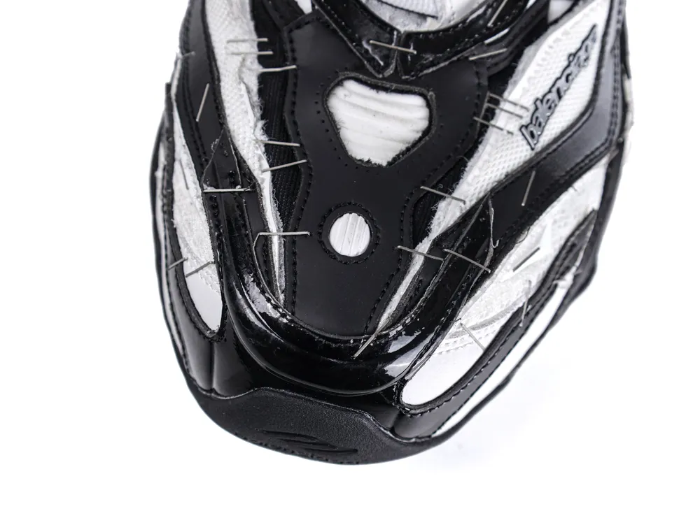 Close-up of a black and white sneaker toe, featuring leather and fabric materials.