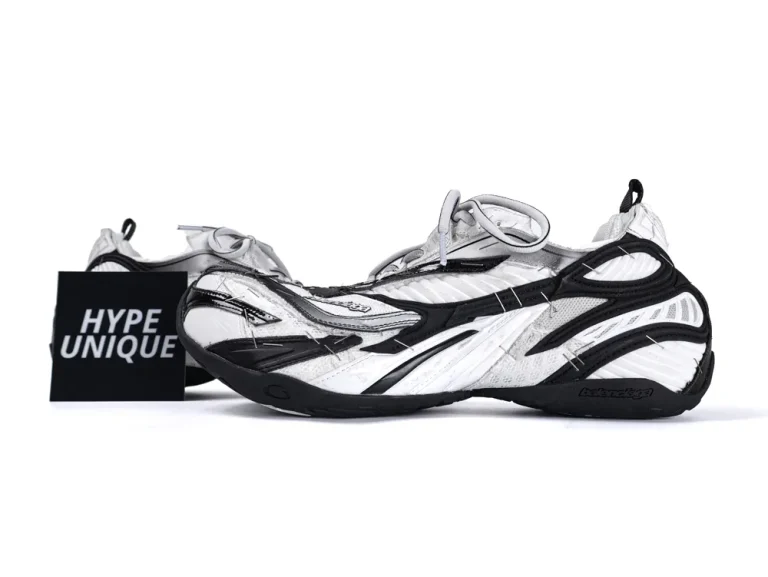Black and white sneakers with mesh and synthetic material, featuring a distinctive layered design.