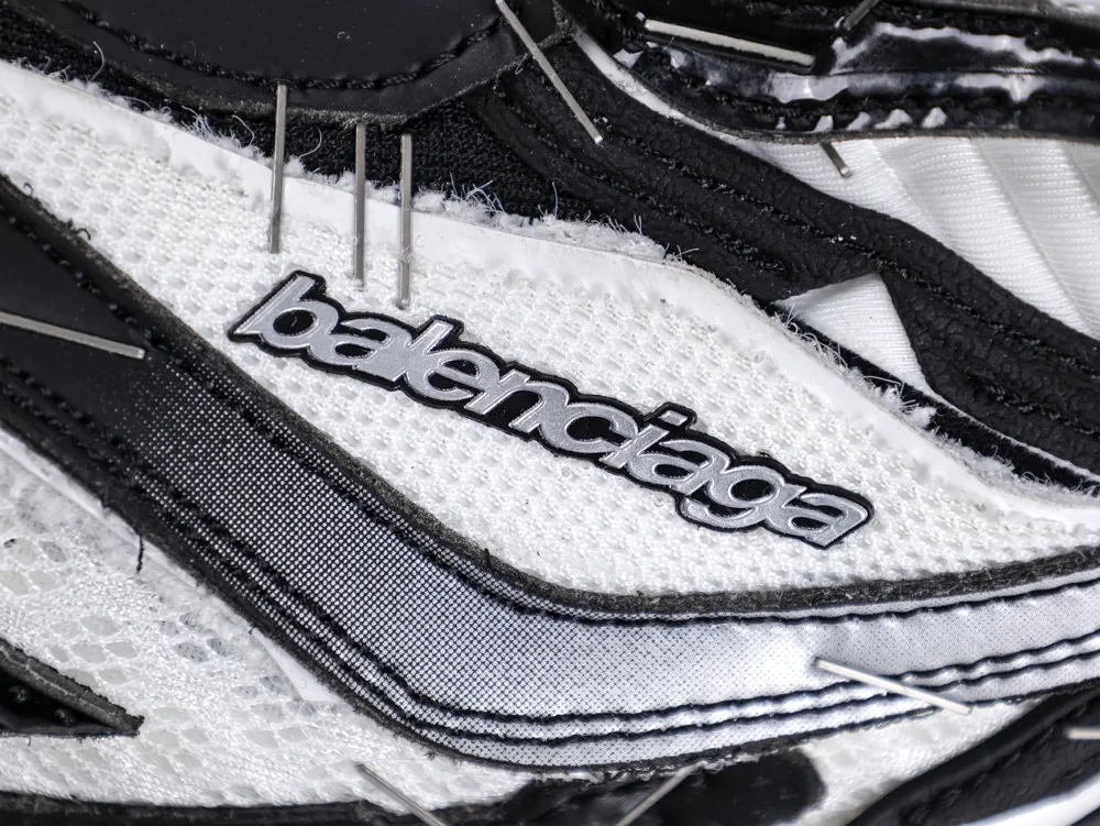 Close-up of a black and white mesh sneaker with a prominent logo detail.