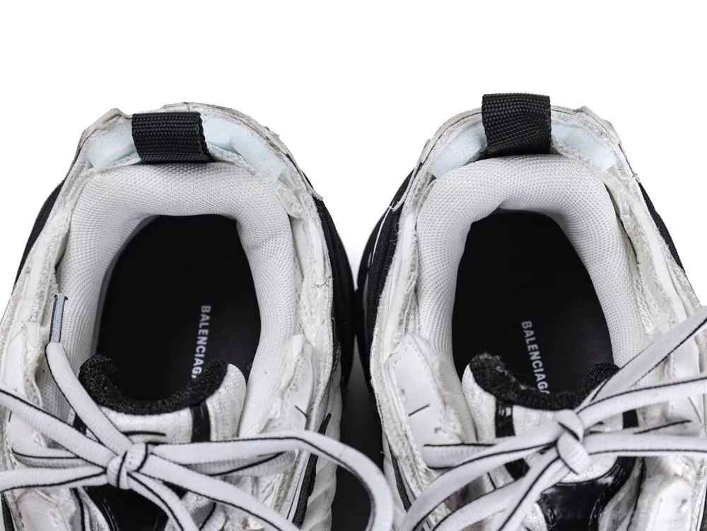 White and black sneakers with fabric lining and laces, top view.