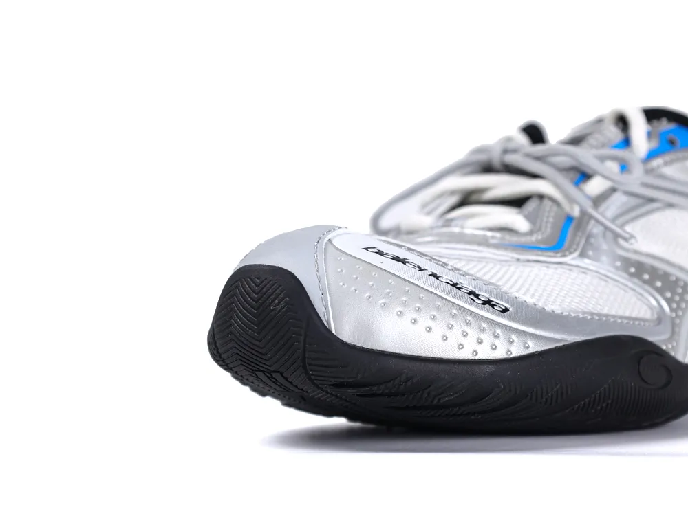 Close-up of a silver synthetic sneaker with a black rubber sole and blue accents.