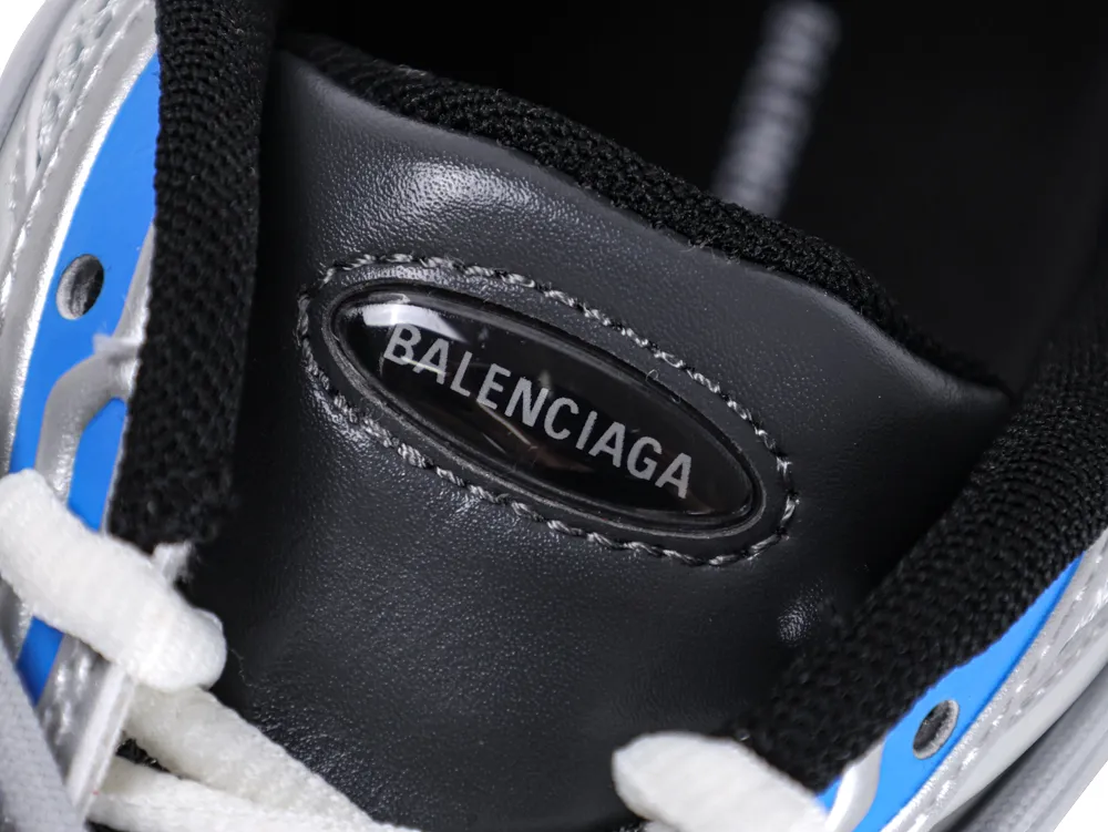 Close-up of a black, blue, and white sneaker with logo on the tongue.