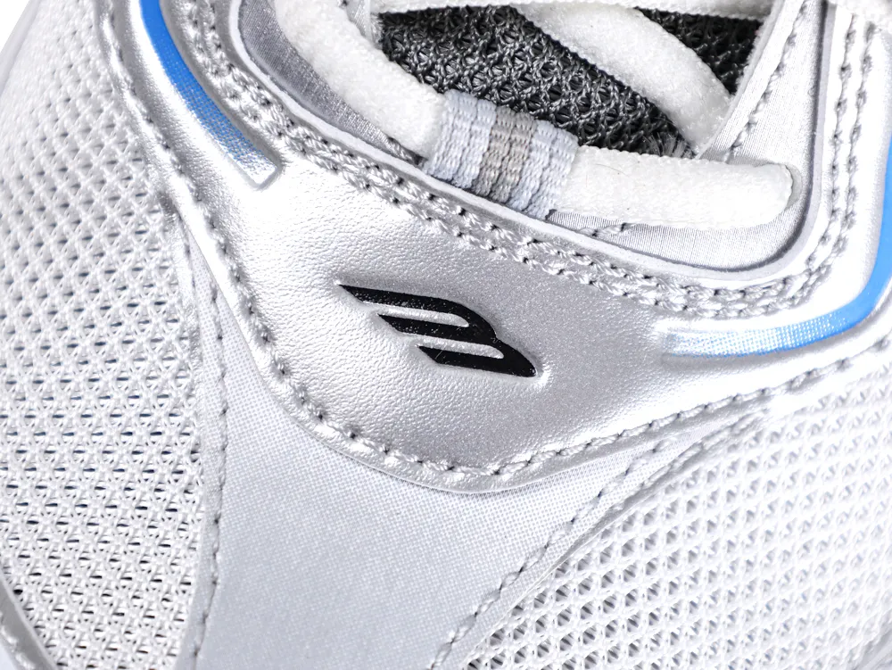 Close-up of silver mesh sneaker, featuring logo detail and blue accents.