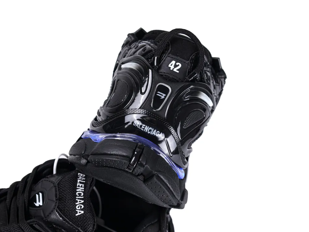 Black sneaker with glossy synthetic accents and a visible white logo on the tongue.