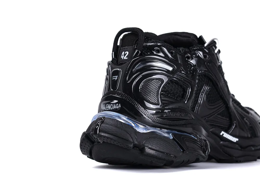 Black sneaker with shiny synthetic material and intricate design details on heel.