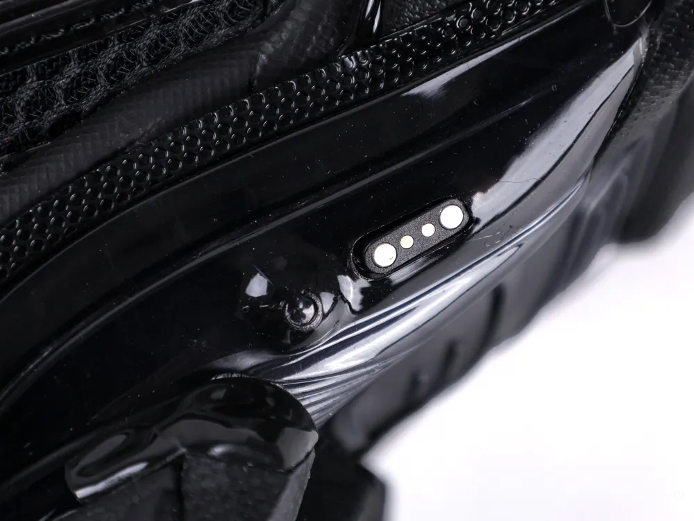 Close-up of a black plastic electronic device part with visible charging connector.