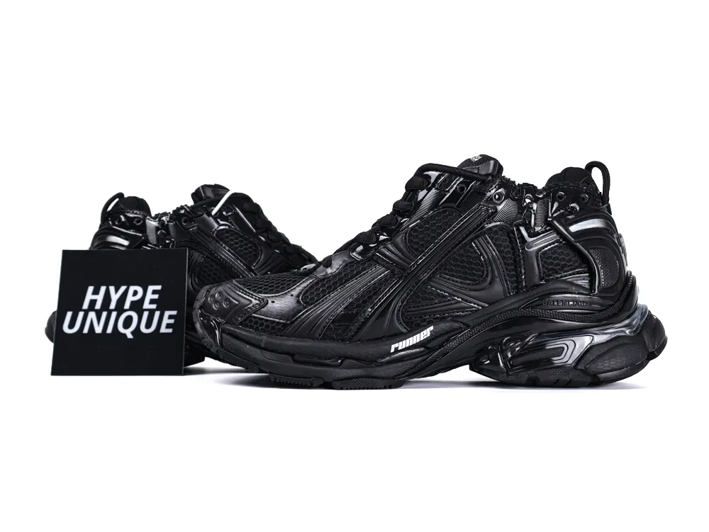 Black leather sneakers with mesh detailing and textured sole, featuring dynamic design elements.