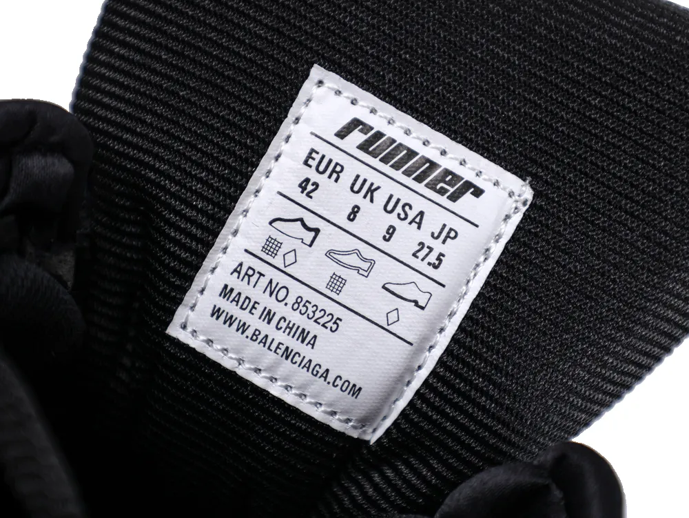 Black fabric shoe with a white label displaying sizing and manufacturing details.