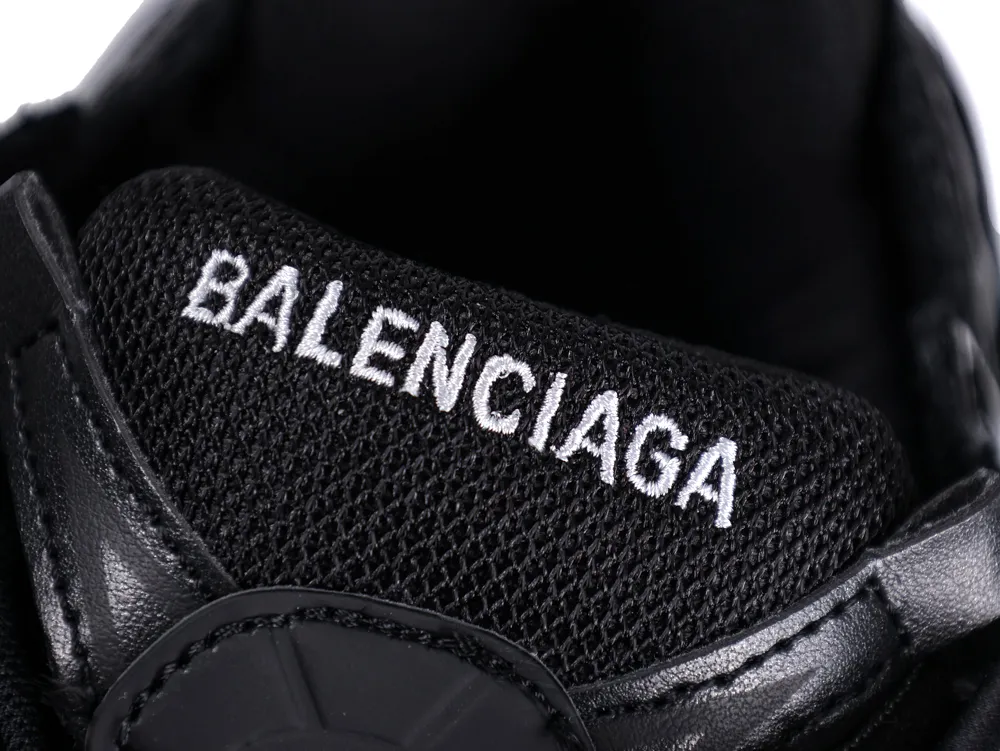 Black mesh and leather shoe tongue with white embroidered text.