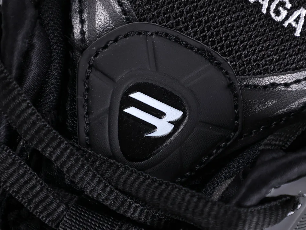Close-up of black leather and mesh sneaker with silver logo detail.