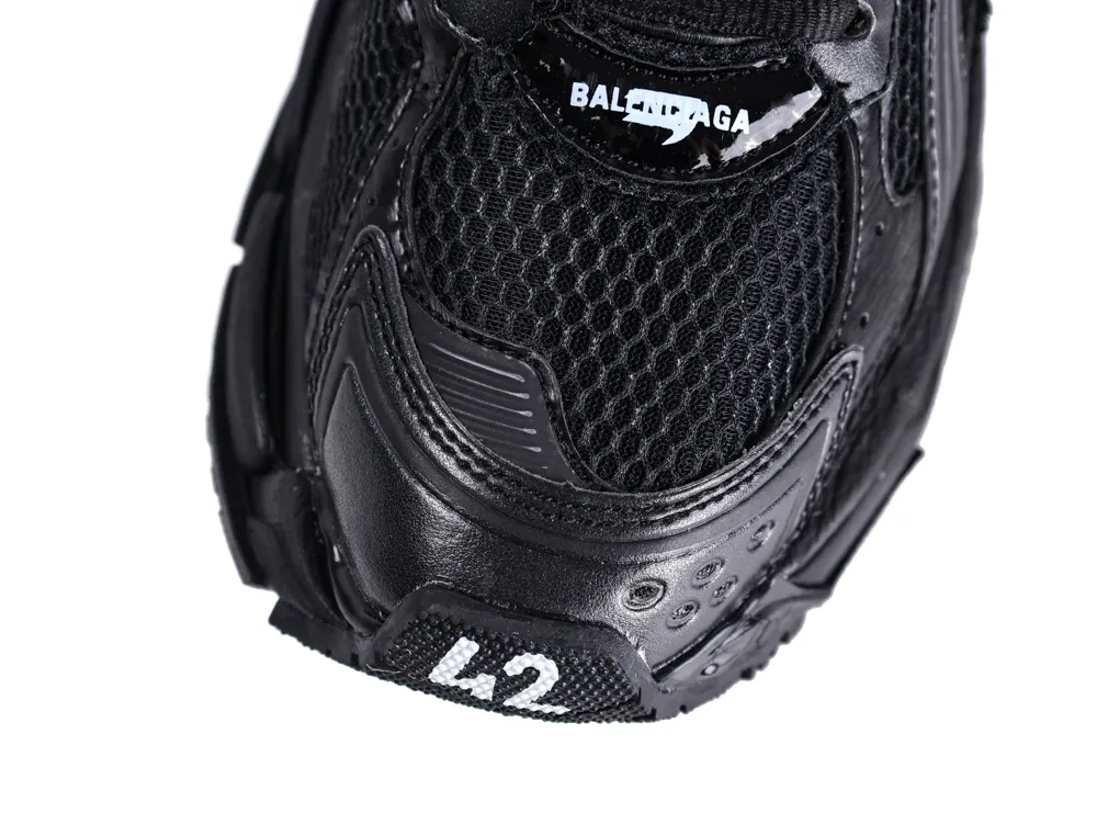 Close-up of black sneaker with mesh and leather materials, showing the toe area.