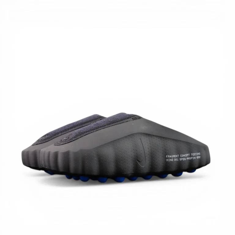 Black textured shoe with blue pebbled outsole, showcasing rugged design and materials.
