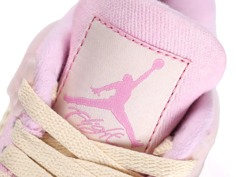 Pink fabric sneaker tongue with embroidered logo, beige laces in foreground.