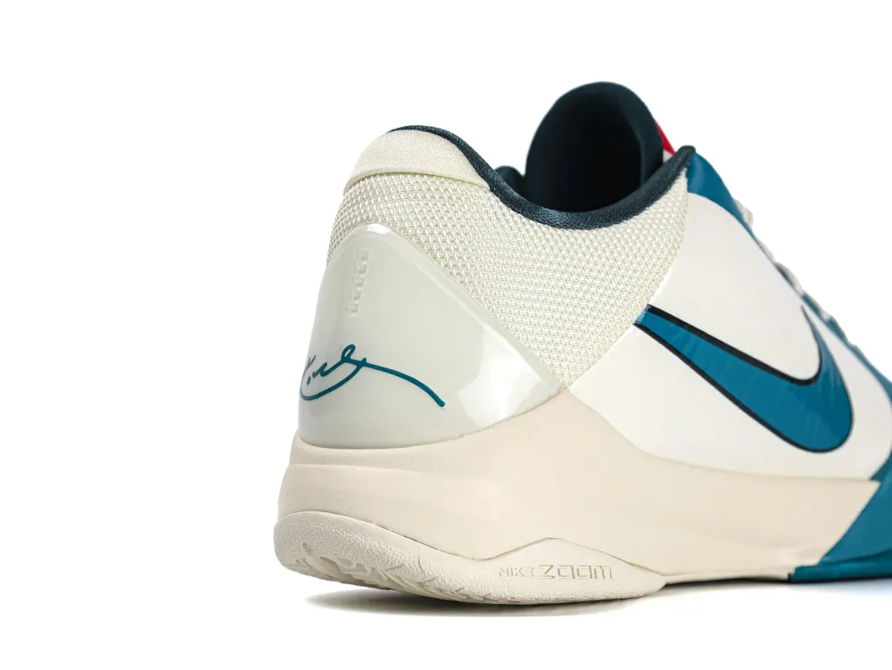 Teal and white sneaker with mesh upper, rubber sole, and embroidered signature detail.