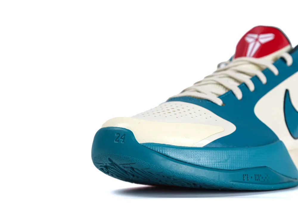 Cream and teal synthetic sneaker with textured sole and red logo accent.