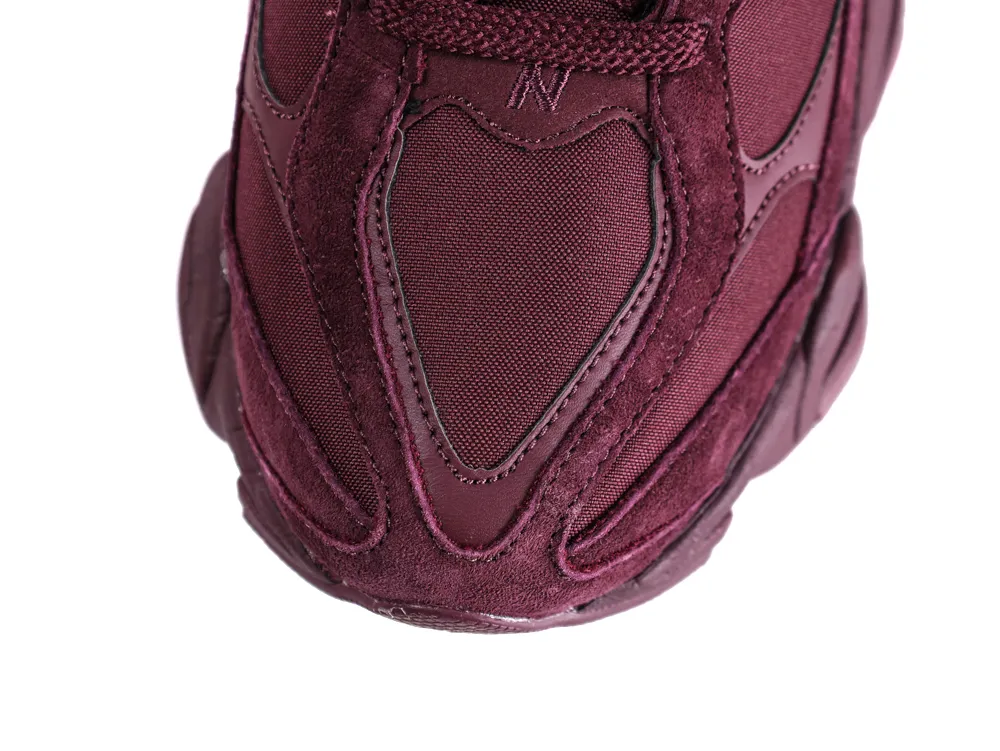 Close-up of maroon sneaker toe made of suede and fabric materials.