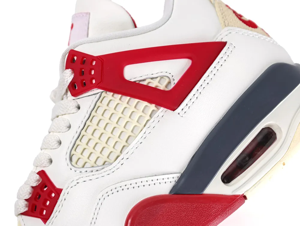 White leather sneaker with red accents and mesh panel detailing.