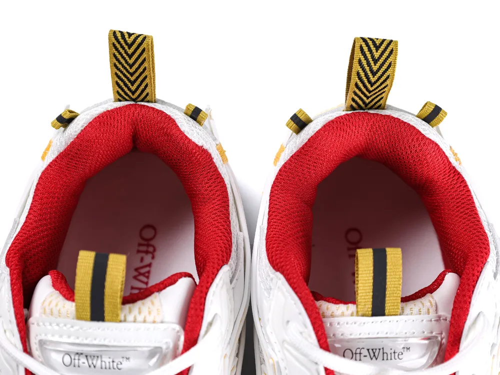 White sneakers with red fabric lining and yellow pull tabs featuring black stripes.