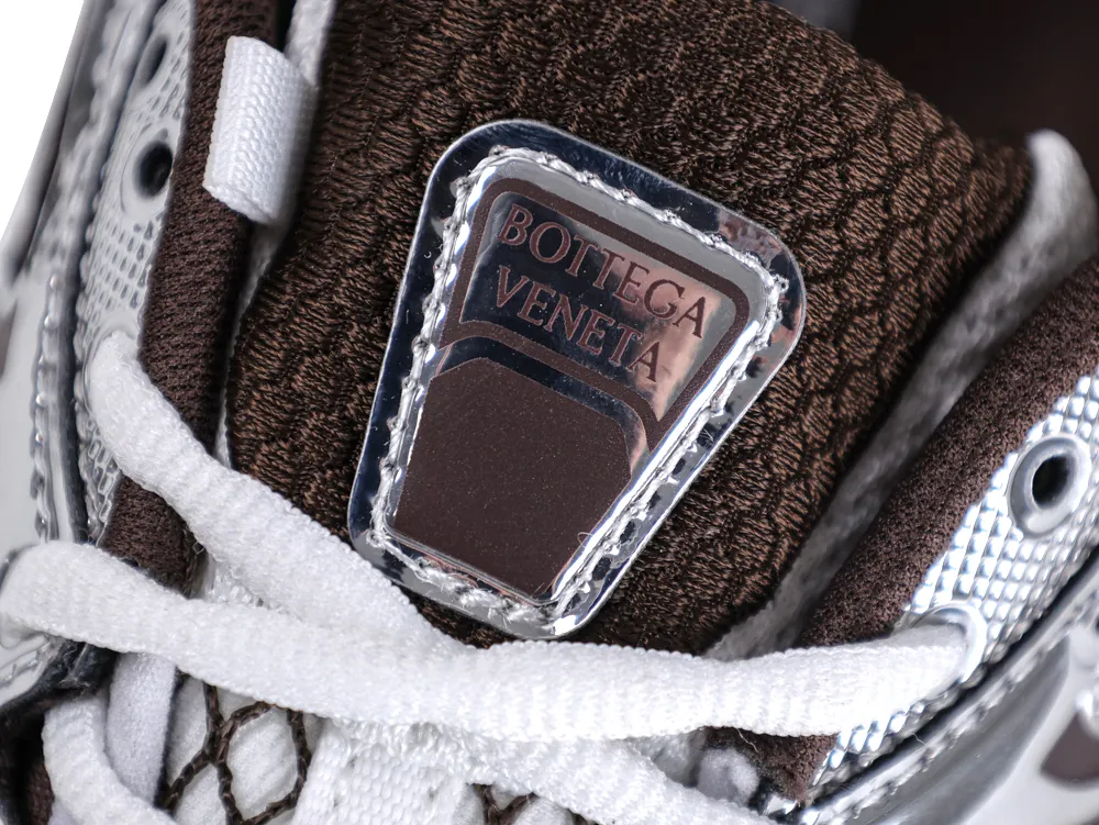 Macro detail of the tongue on Bottega Veneta Orbit Sneaker with embossed silver logo plaque