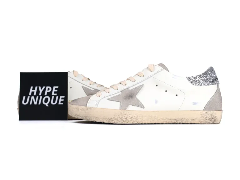 Side view of white Golden Goose sneakers with black branding card