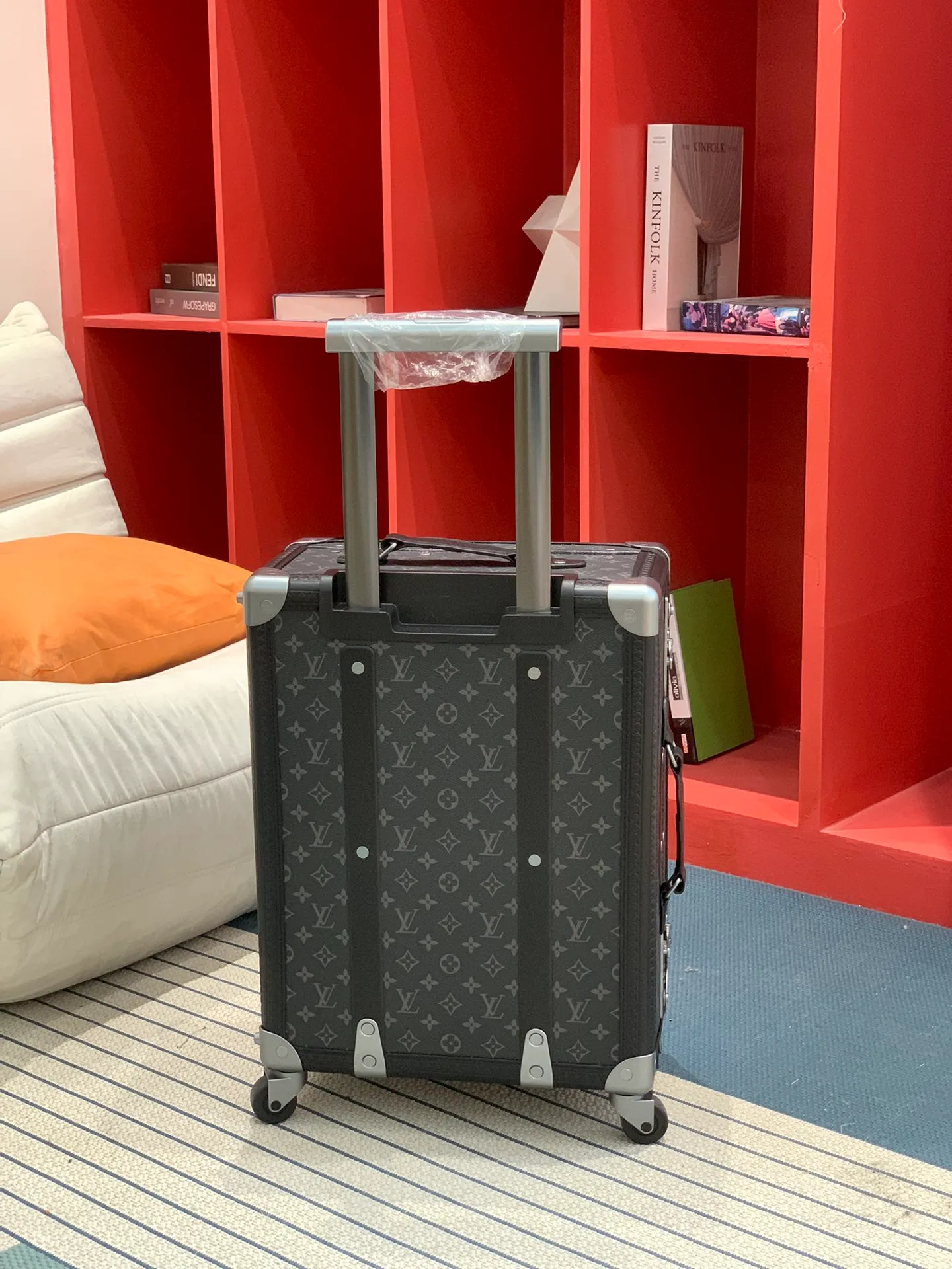 Black monogram rolling trunk rear view with extended handle